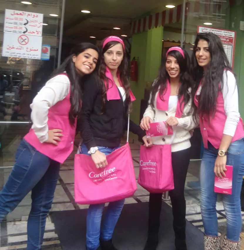 Carefree promoters in pink vests with branded bags at a mall entrance