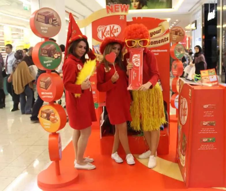 KitKat promoters in red costumes at a launch stand inside a mall