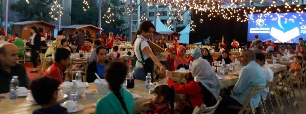 Families at long tables in a decorated seasonal souk